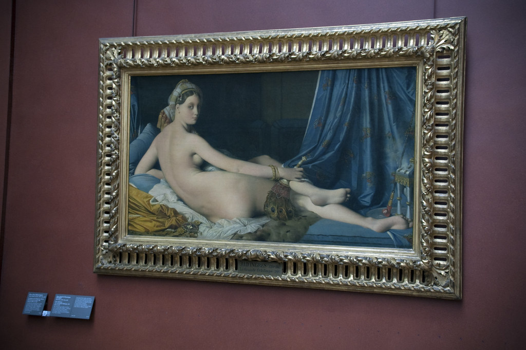 Photo d'un tableau représentant une femme nue de dos nous regardant