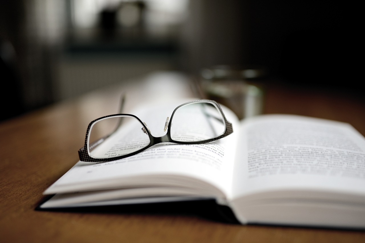 Photo de lunettes posées sur un livre ouvert