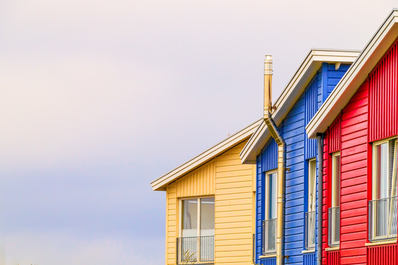 Photo de trois maisons, une jaune, une rouge et une bleue